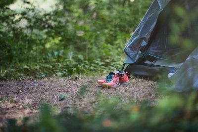Chaussures de randonnée et tente dans la nature