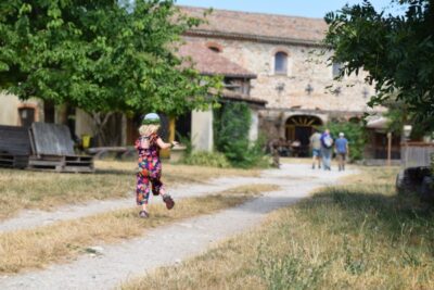 Petite fille qui court sur le chemin menant à la ferme dans la nature