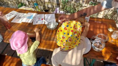 Deux enfants en été participant à un atelier fabrication de beurre de la ferme