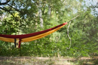 Hamac rouge et orange suspendu dans la nature