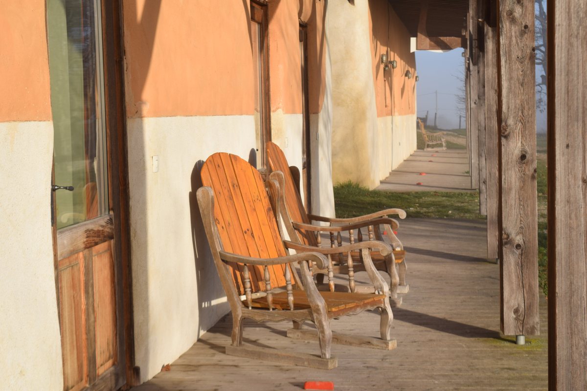 hiver-terrasse-fauteuils-soleil-amanins Fauteuils en bois au soleil sur la terrasse des bâtiments écoconçus aux Amanins en hiver