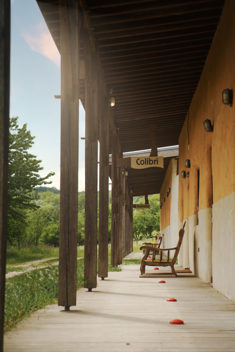 terrasse avec piliers en bois, bâtiment d'hébergement écoconstruit